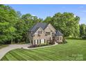 Stately brick home with lush lawn, manicured landscaping, and a winding driveway at 3398 Millstone Creek Rd, Lancaster, SC 29720