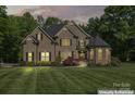 Charming brick home featuring manicured landscaping and an inviting front entrance at dusk at 3398 Millstone Creek Rd, Lancaster, SC 29720