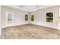 Living room featuring wood floors, a back door to the yard, and bright windows at 5053 Arbordale Way, Mount Holly, NC 28120