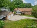 Sprawling brick home with a two-car garage, screened porch, long driveway, and lush green landscaping at 5522 Sharon Rd, Charlotte, NC 28210
