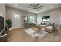 Bright living room with light wood floors, neutral walls, contemporary furnishings, and a stylish ceiling fan at 5705 White St, Fort Lawn, SC 29714