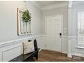 Bright foyer featuring beautiful wainscoting, hardwood floors, and a decorative accent piece at 7209 Brookline Pl, Huntersville, NC 28078