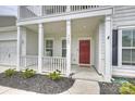 Inviting front porch with red front door and manicured landscaping at 7209 Brookline Pl, Huntersville, NC 28078