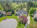 An aerial view showcasing this stunning property with mature trees, lush landscaping, and well manicured lawn at 7280 Woodside Ct, Denver, NC 28037