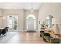 Bright foyer boasting light wood floors, a statement mirror, console table, and modern light fixture at 7280 Woodside Ct, Denver, NC 28037