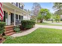 Brick steps lead to a covered porch with nice landscaping and lawn at 9101 Strattonville Ct, Huntersville, NC 28078