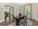 Well-lit office featuring hardwood floors, a modern desk, and decorative curtains at 10201 Daufuskie Dr, Charlotte, NC 28278