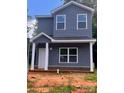 Two-story home features gray siding, white trim, covered porch and a well-lit, eye-catching, exterior elevation at 115 Allen St, Rock Hill, SC 29730