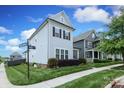 Well-maintained home featuring light-blue siding, black shutters, and lush landscaping on a sunny corner lot at 13624 Jacks Ln, Pineville, NC 28134