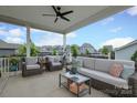 Relaxing covered patio with stylish furniture, ceiling fan, and neighborhood views at 13624 Jacks Ln, Pineville, NC 28134