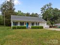 Charming ranch-style home with blue shutters, bright blue front door, a covered porch, and manicured landscaping at 1401 Thompson Ave, Charlotte, NC 28216