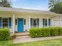 Charming ranch-style home with blue shutters, bright blue front door, a covered porch with a brick entryway at 1401 Thompson Ave, Charlotte, NC 28216