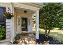 Welcoming front porch with a decorative door, potted plants, and cozy 'Welcome' mat at 16117 Wrights Ferry Rd, Charlotte, NC 28278