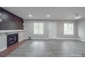 Spacious living room featuring wood accent wall fireplace, grey flooring, and natural light at 1847 J Julian Ln # A, Charlotte, NC 28208