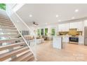 Open-concept living space featuring hardwood floors, a modern kitchen, and a staircase with white railings at 1847 Vinton St, Charlotte, NC 28216