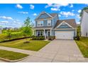 Attractive two-story home with blue siding, a manicured lawn, and a double driveway in a walkable neighborhood at 194 Canada Dr, Statesville, NC 28677