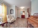 Bright living room featuring hardwood floors, a decorative mirror, and a classic piano at 2037 Christopher Wood Ct, Indian Land, SC 29707