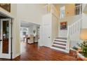 Elegant foyer with hardwood floors, a staircase, and a view into the adjacent dining room at 21300 Crown Lake Dr, Cornelius, NC 28031