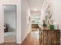 Inviting hallway with hardwood floors, console table, and neutral paint, leading to the living area at 2202 Cherrybark Ct, Denver, NC 28037