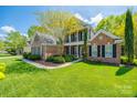 Charming two-story brick home with lush green lawn and mature landscaping at 2235 Legacy Oak Dr, Waxhaw, NC 28173