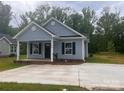 Inviting single-story home with a classic design, covered porch, and a spacious concrete driveway at 225 Baker St, Rock Hill, SC 29730