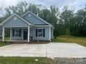 Attractive single-story home with a covered porch, black shutters, and a modern concrete driveway at 225 Baker St, Rock Hill, SC 29730