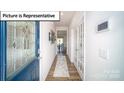 Inviting hallway with wood floors and a decorative front door that leads to other areas of the house at 3018 Sassafras Trl, Gastonia, NC 28056
