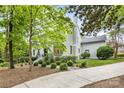 Beautifully landscaped yard with a charming brick home, featuring a manicured lawn and mature trees at 310 Whitestone Rd, Charlotte, NC 28270