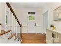 Welcoming foyer featuring hardwood floors, a staircase with white trim, and a classic front door with glass panels at 310 Whitestone Rd, Charlotte, NC 28270
