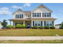 Inviting two-story home boasting a covered porch, neat landscaping, and stylish black shutters, perfect for curb appeal at 4321 Hornyak Dr, Monroe, NC 28110
