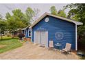 Exterior shot of the blue home displaying front lawn, driveway, and a cozy patio area with seating at 4810 Shea Ct, Monroe, NC 28110