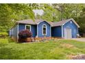 Blue single-story home with a well-manicured lawn, landscaping, and a welcoming facade at 4810 Shea Ct, Monroe, NC 28110