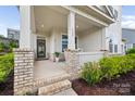 Inviting front porch with brick columns and a cozy seating area at 528 Rock Skip Way, Fort Mill, SC 29708