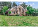 Stately brick home with lush green lawn, mature trees, and tasteful landscaping at 7887 Mountain Shore Dr, Sherrills Ford, NC 28673