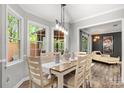 Inviting dining room with natural light, a farmhouse-style table, and views into the living room at 8819 Kishorn Ct, Charlotte, NC 28215