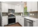 Modern kitchen with white cabinets, stainless steel appliances, and a stylish backsplash at 901 Southland Rd, Huntersville, NC 28078