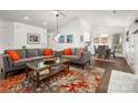 Bright living room with modern sofas, a glass coffee table, and an adjacent dining area at 901 Southland Rd, Huntersville, NC 28078