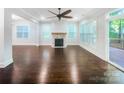 Open living room features a fireplace, hardwood floors, large windows, and access to an outdoor deck at 911 Balsam Ter, Charlotte, NC 28214