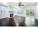Well-lit living room with hardwood floors, fireplace, large windows, and sliding doors to a deck at 911 Balsam Ter, Charlotte, NC 28214