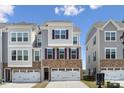 New construction townhome showcasing brick accents, neutral siding, and a two-car garage at 9823 Oaklawn Nw Blvd, Huntersville, NC 28078