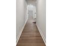 Hallway with hardwood floors leads to stairs, showing the entry's bright, clean design at 9823 Oaklawn Nw Blvd, Huntersville, NC 28078