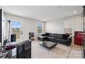 Modern living room features a black leather sectional, a large window, and neutral decor at 9823 Oaklawn Nw Blvd, Huntersville, NC 28078