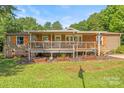 Cozy home boasts covered porch, wooden railings, and well-maintained landscaping at 1005 Caldon Dr, Stanley, NC 28164