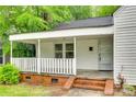 Inviting covered porch with brick steps and white railing, perfect for relaxing at 146 Walnut St, Chester, SC 29706