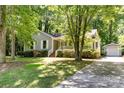 Well-maintained single-story home with a detached garage and a long driveway surrounded by trees at 16320 Peach Grove Ln, Charlotte, NC 28277