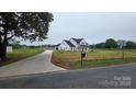 Beautiful white farmhouse with a long driveway, ample yard space, and classic architectural details at 1706 Ruben Rd, Monroe, NC 28112