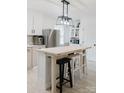Stylish kitchen featuring a central island with seating, white cabinets, and modern lighting fixtures at 18 Shannon Ct, Newton, NC 28658