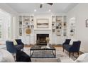 Elegant living room with built-in bookshelves flanking a fireplace and stylish seating arrangement at 1806 Asbury Hall Ct, Charlotte, NC 28209