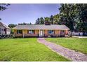 Charming brick home with manicured lawn, decorative shutters, complemented by a stone pathway leading to the front door at 209 Woodstream Cir, Mooresville, NC 28117