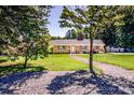 Traditional brick home with shutters, landscaping, and a stone path leading to the front door, framed by mature trees at 209 Woodstream Cir, Mooresville, NC 28117